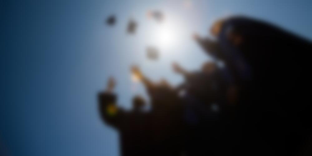 Students toss their graduation caps into the air.